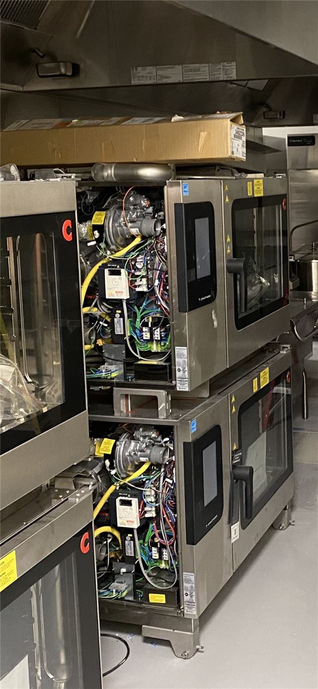 Stacked commercial combi ovens opened up for electrical service