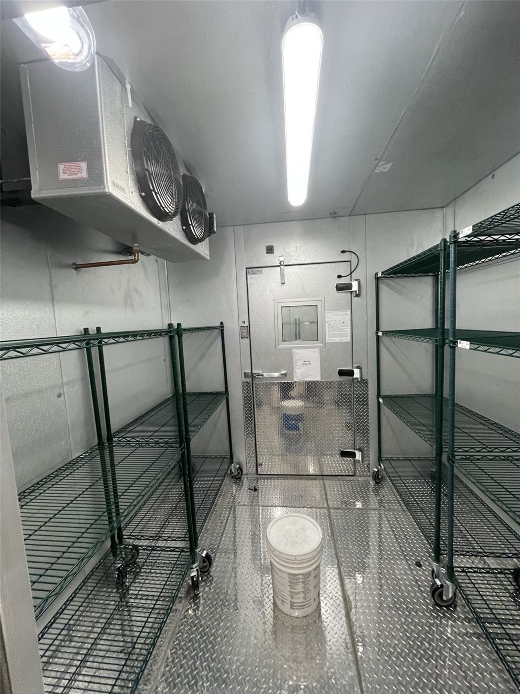 Walk-in cooler interior with wire shelving and evaporator
