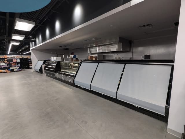 Long run of refrigerated deli cases in a new grocery store